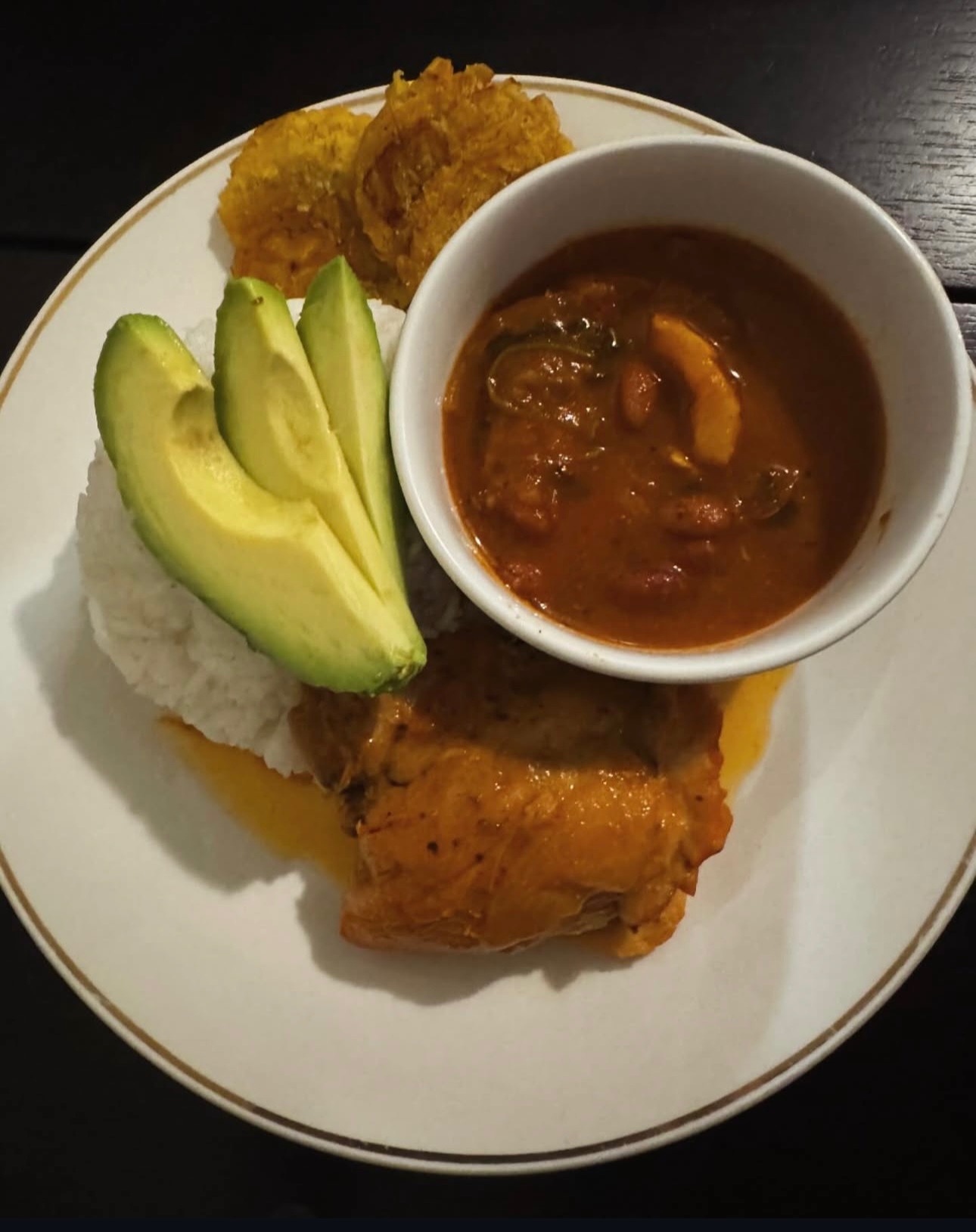 Dominican baked chicken with white rice, pinto beans, avocado and fried plantain